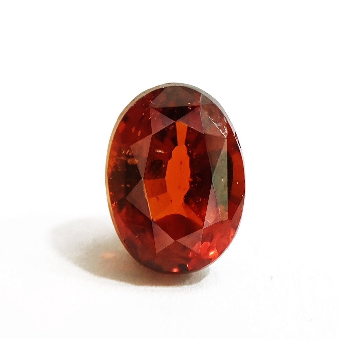 A close-up of a Natural African Gomedh (Hessonite Garnet) gemstone with a deep reddish-brown hue and radiant clarity.
