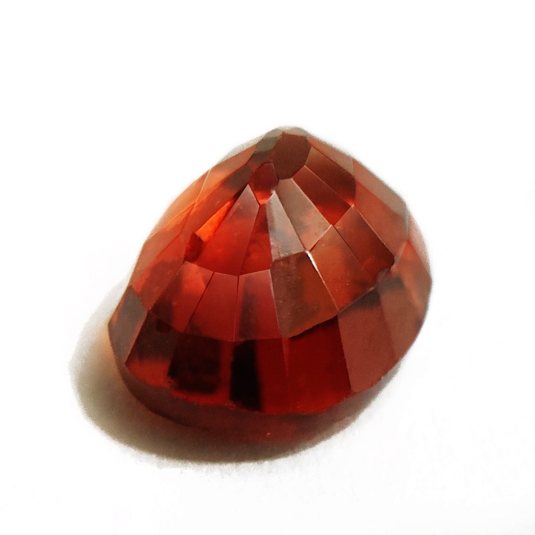 A close-up of a Natural African Gomedh (Hessonite Garnet) gemstone with a deep reddish-brown hue and radiant clarity.