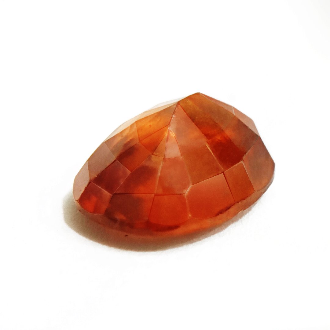 A close-up of a Natural African Gomedh (Hessonite Garnet) gemstone with a deep reddish-brown hue and radiant clarity.