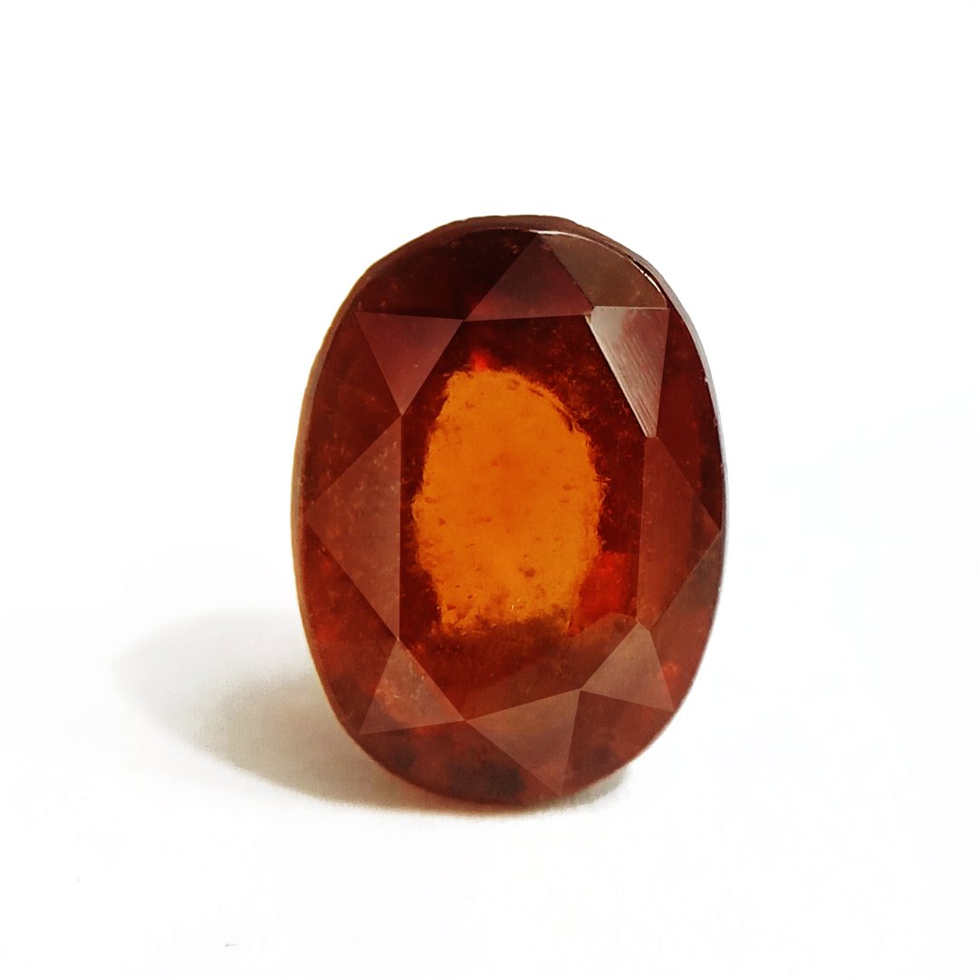 A close-up of a Natural African Gomedh (Hessonite Garnet) gemstone with a deep reddish-brown hue and radiant clarity.
