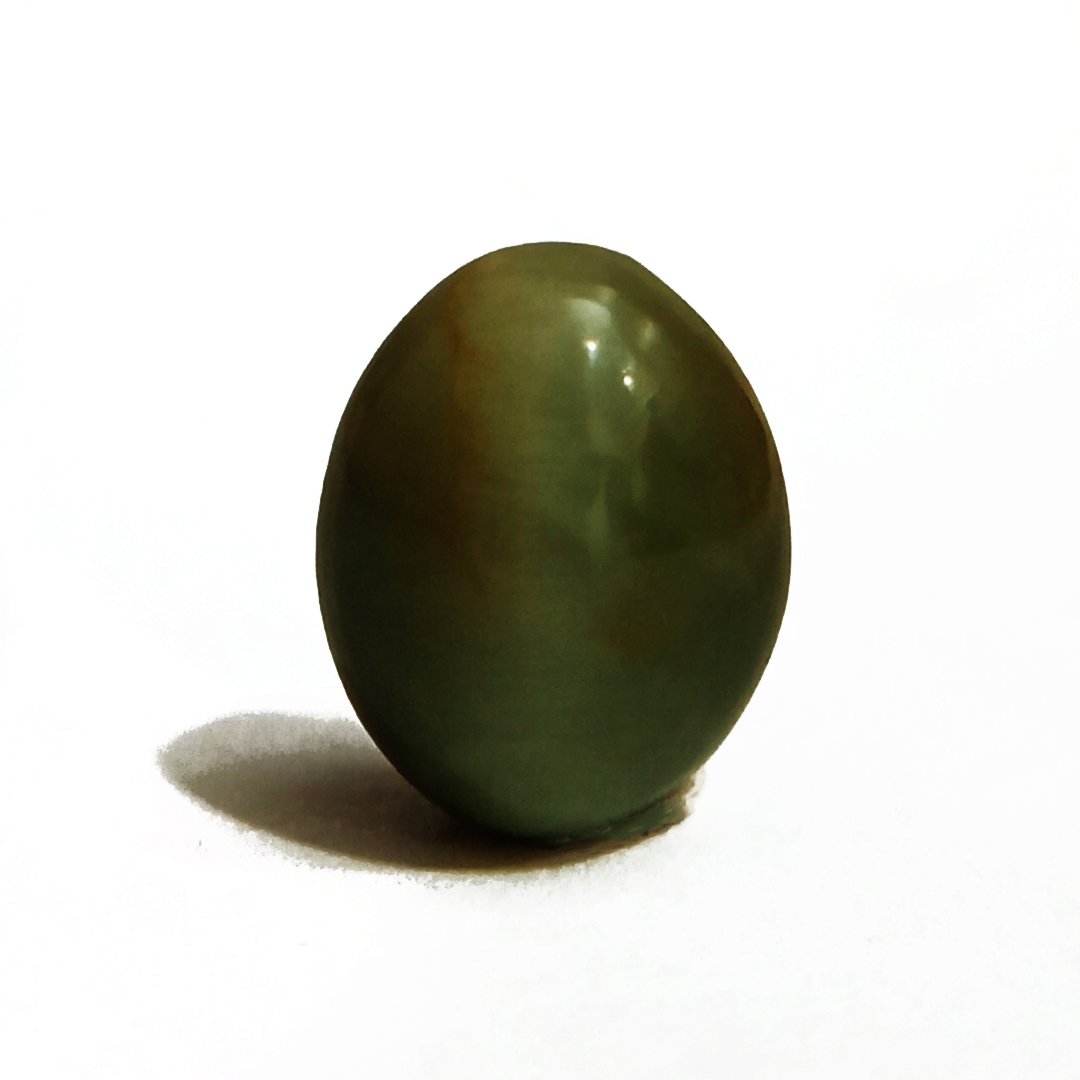 Mystical Indian Cat's Eye gemstone with a striking chatoyant effect, symbolizing protection, insight, and prosperity.