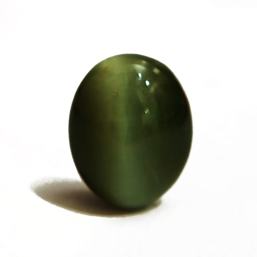 Mystical Indian Cat's Eye gemstone with a striking chatoyant effect, symbolizing protection, insight, and prosperity.
