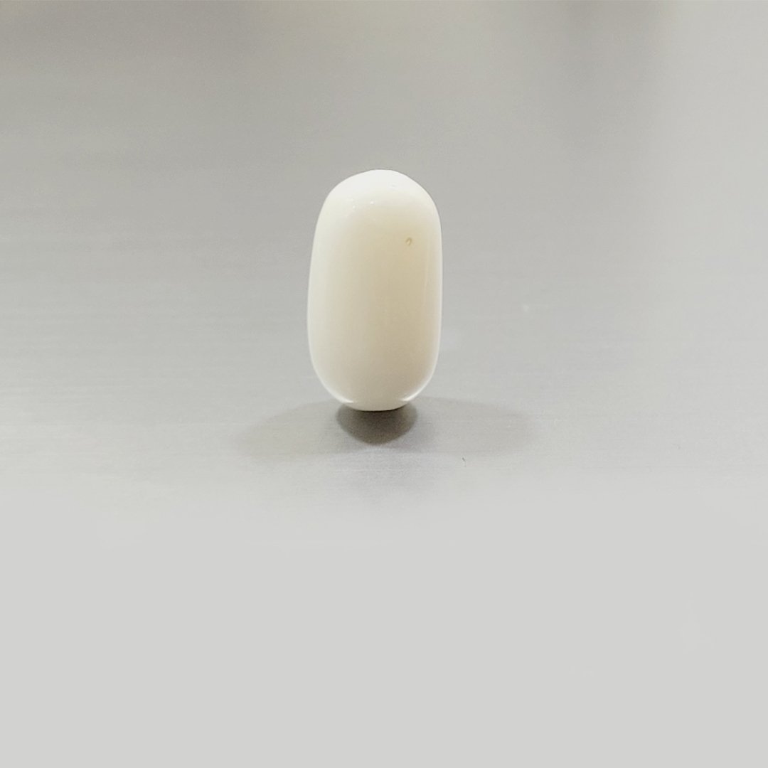 A close-up of a Natural White Coral gemstone, showcasing its smooth texture and milky white hue.