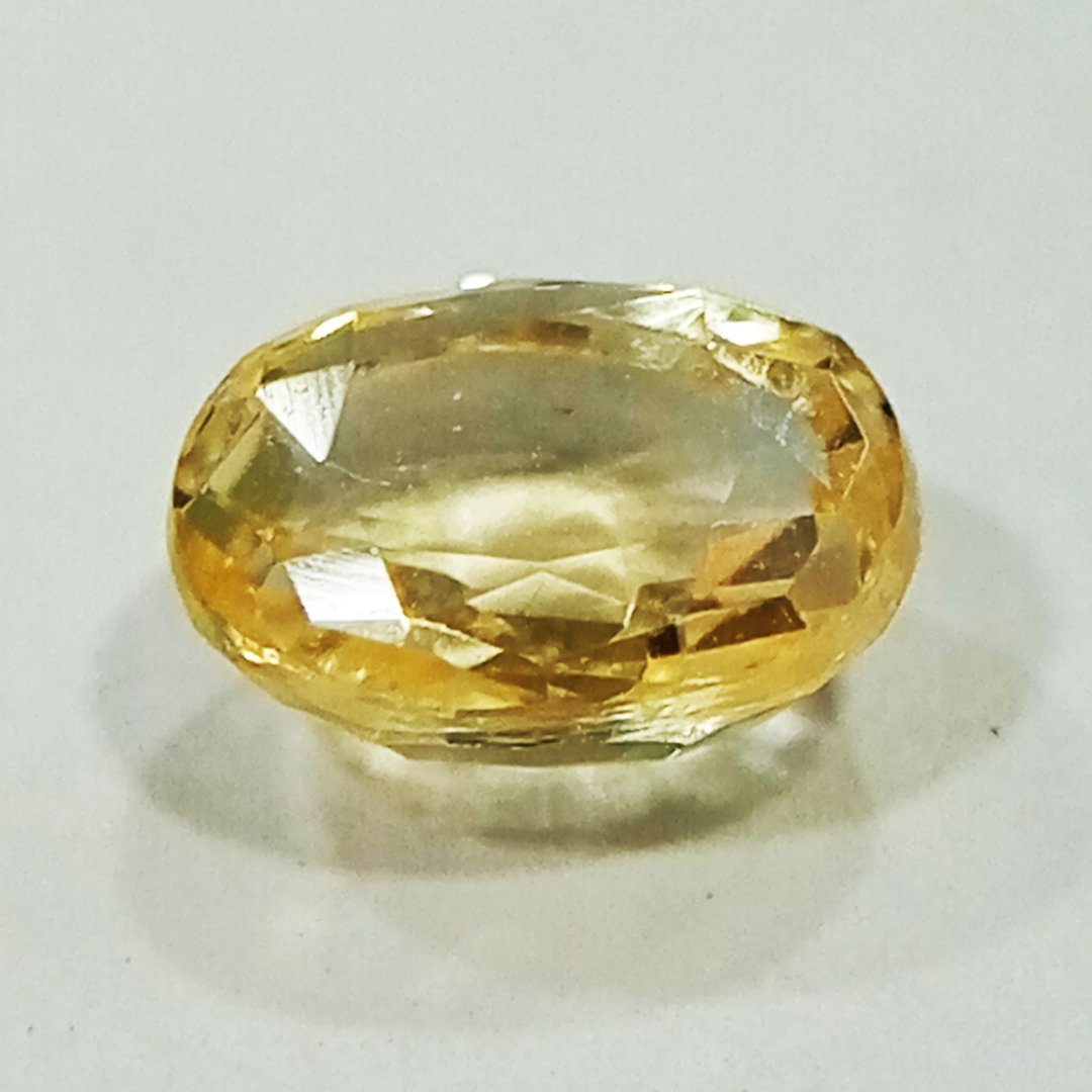 A high-quality Yellow Sapphire stone, known for its astrological benefits and association with Jupiter.