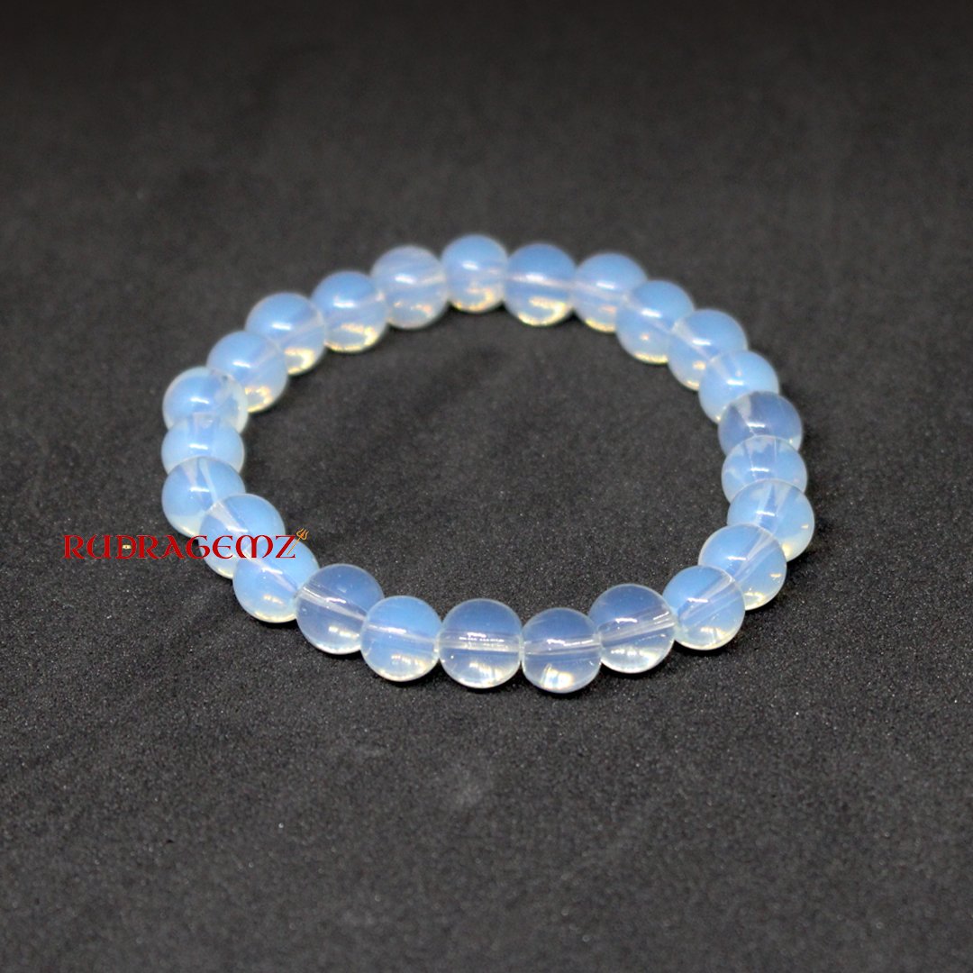A close-up of an Opalite Bracelet featuring smooth, luminous beads that reflect a soft glow.