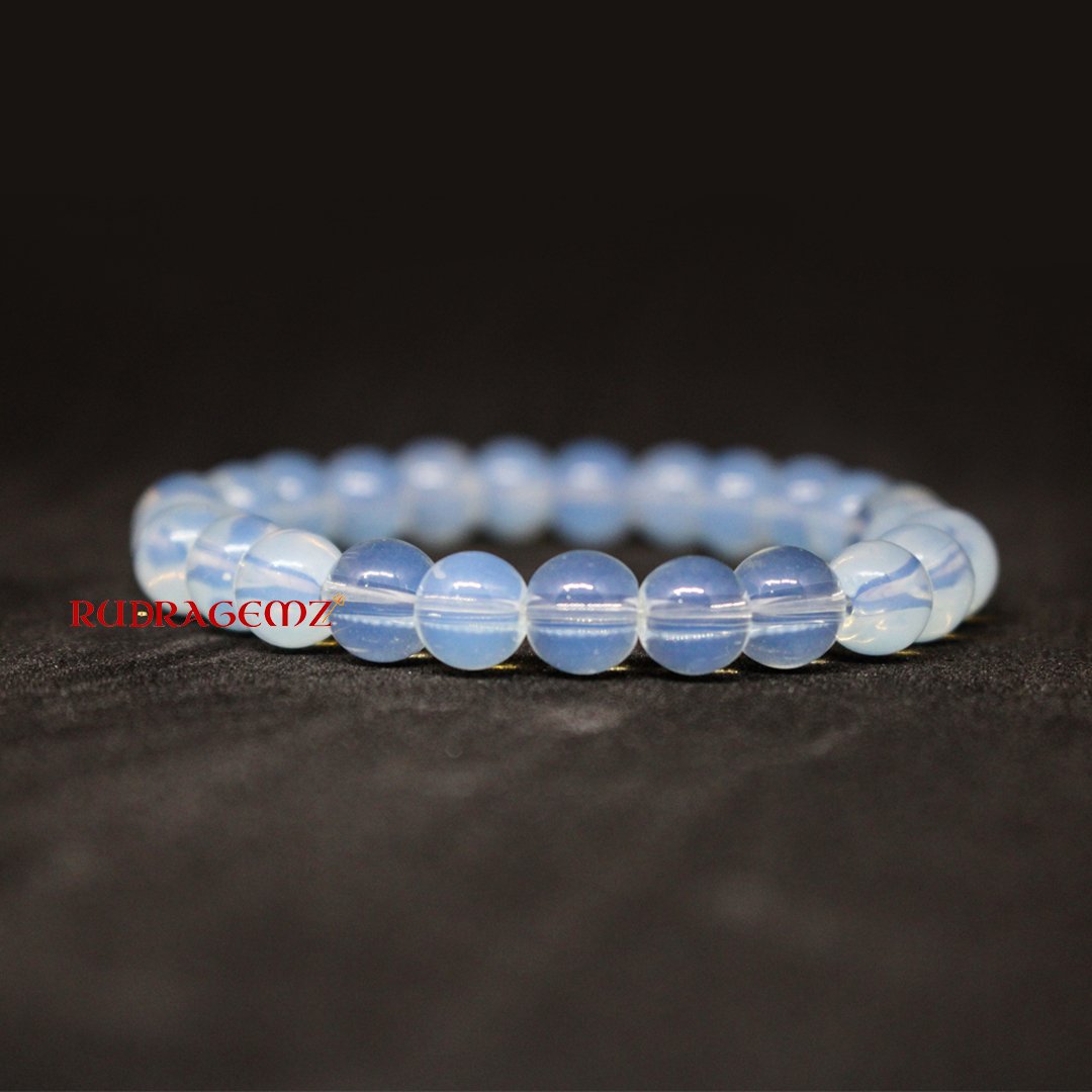 A close-up of an Opalite Bracelet featuring smooth, luminous beads that reflect a soft glow.