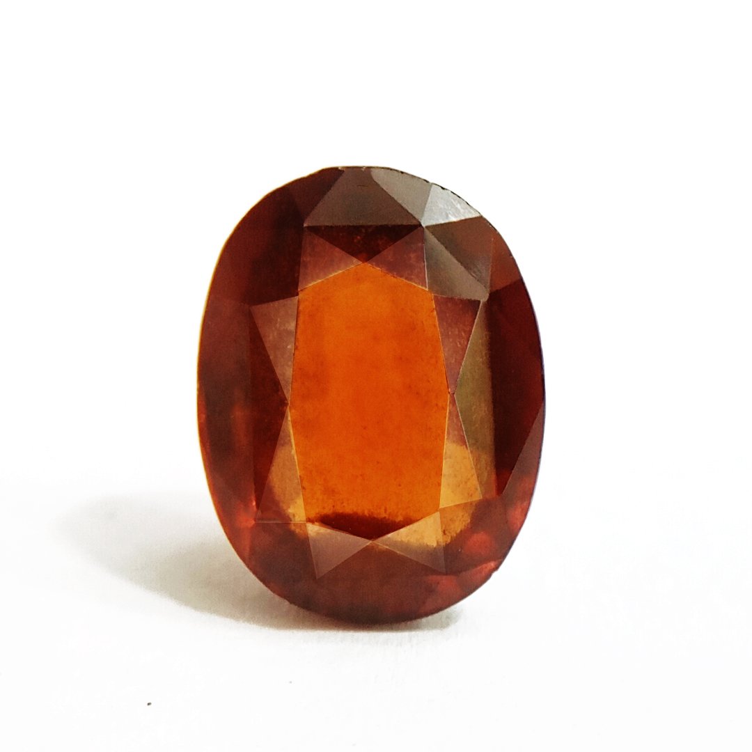 A close-up of a Natural African Gomedh (Hessonite Garnet) gemstone with a deep reddish-brown hue and radiant clarity.