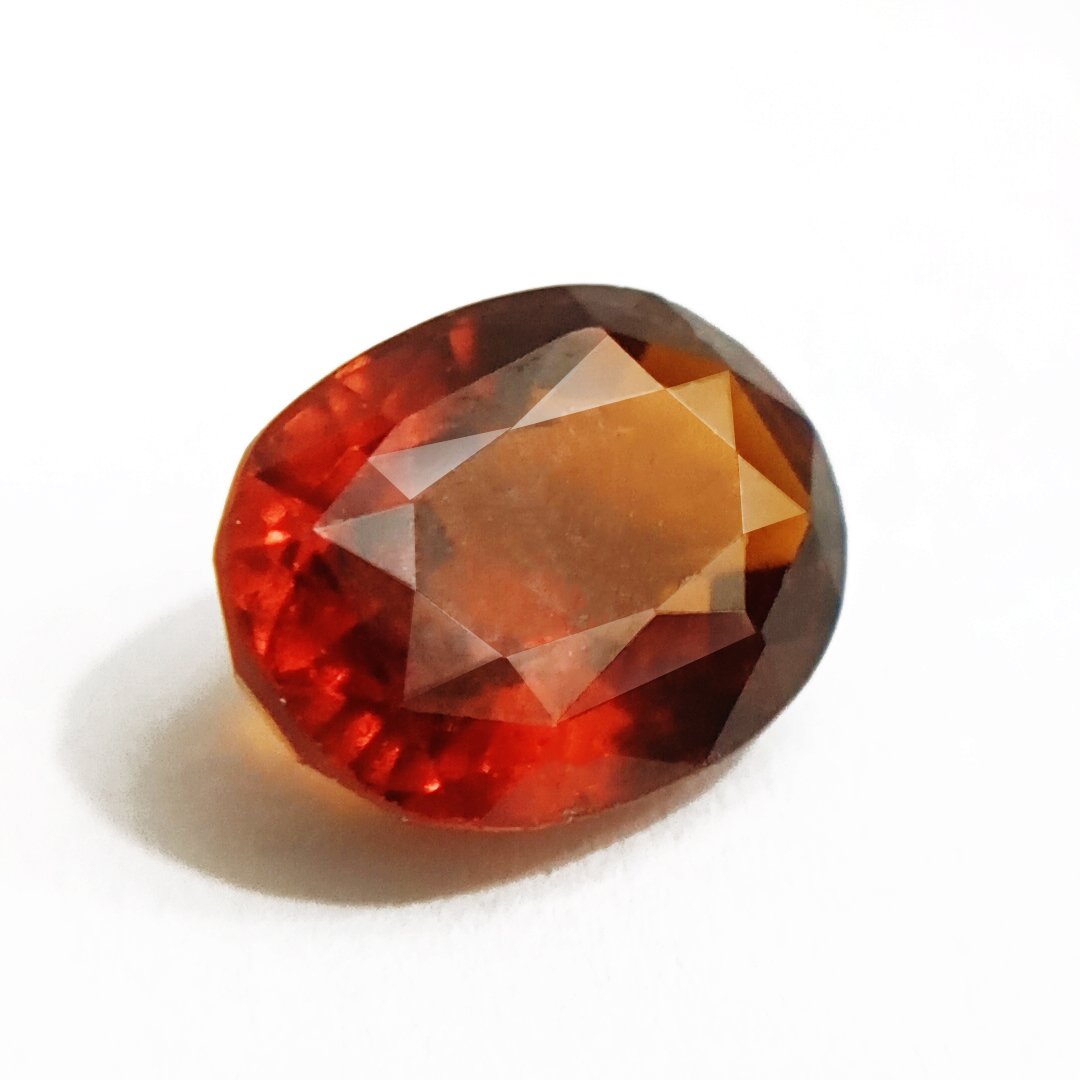 A close-up of a Natural African Gomedh (Hessonite Garnet) gemstone with a deep reddish-brown hue and radiant clarity.
